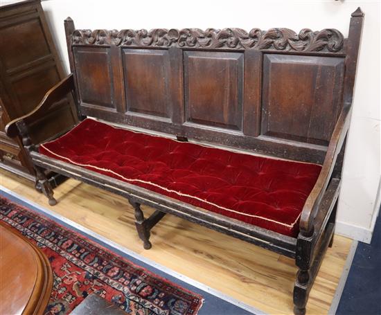 A mid 18th century oak settle with four fielded panels W.183cm